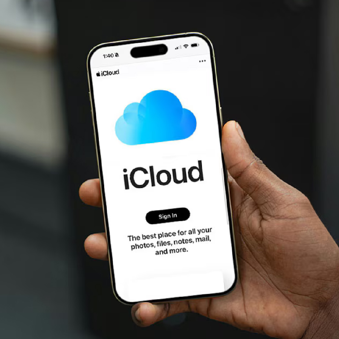 Hand holding a phone showing the iCloud sign-in screen